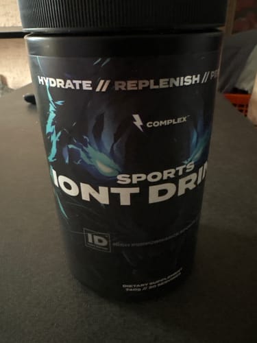 Close-up of the reviewer's black tub of Sports Iont Drink on a table.