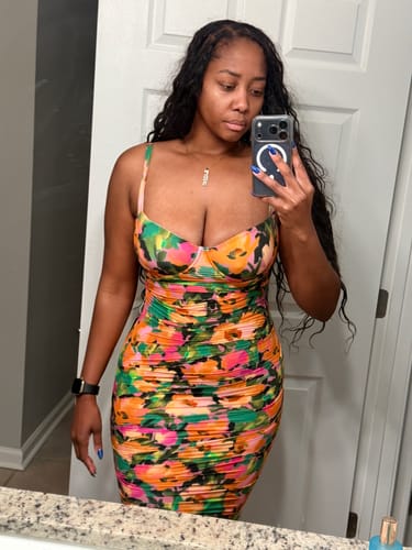 Reviewer in the colorful, floral Naked Print Ruched Dress taking a mirror selfie.