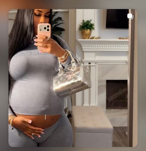 Reviewer taking a mirror selfie wearing the form-fitting grey Seamless Logo Turtleneck.