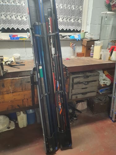 Recensent toont twee HARDCASE RBS koffers vol met vishengels in een werkplaats.