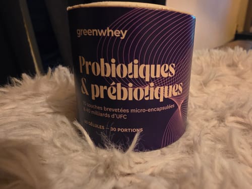 Pot de Probiotiques & Prébiotiques d'un client sur une surface blanche et duveteuse.