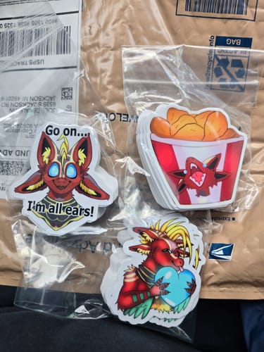 Customer's three packs of custom stickers, showing colorful character designs.