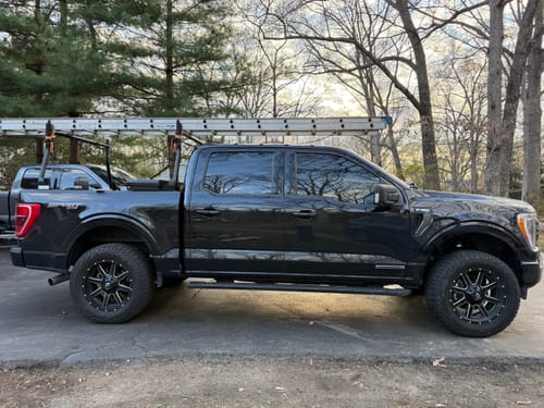 Customer's black Ford F150 shown from the side, displaying the lifted stance from the 2.5 inch front leveling lift kits.