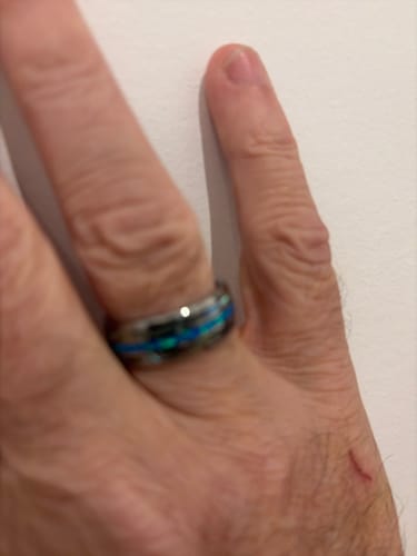 Close-up: Reviewer's hand wearing the Vanguard ring, showing its brilliant colorful inlay.