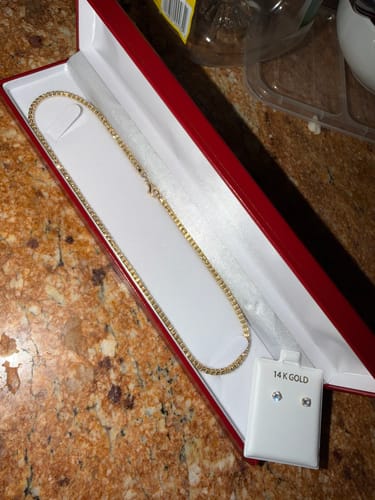 Reviewer's 14 K Providence gold chain displayed in a red jewelry box next to a pair of stud earrings.