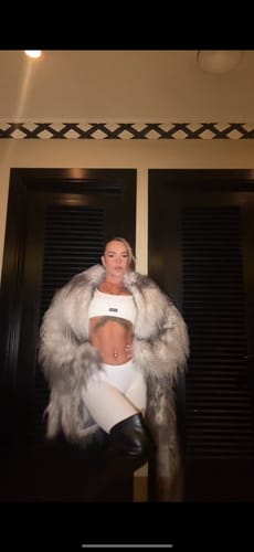 Reviewer posing in white Seamless LowRise Leggings, styled with a crop top and a large fur coat.