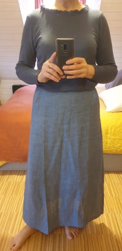 Cliente montrant sa jupe longue Maya en lin chiné de couleur denim.