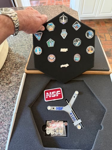 Customer unboxing the SpaceX Starship Flight Pin Collection, showing the display tile and the serialized mount kit in foam packaging.