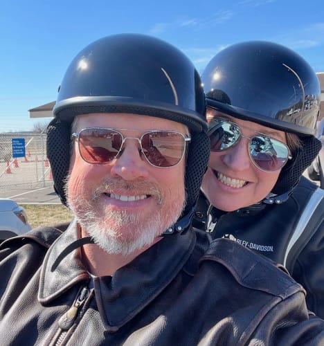A customer and passenger smiling while wearing their low-profile, gloss black DOT Beanie Helmets.