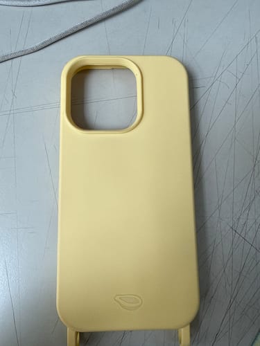 A Case Amarelo Manteiga do cliente, mostrando o recorte da câmera e os encaixes inferiores para alça.