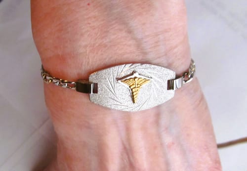 Close-up of a reviewer wearing the Medical ID Figaro Link Bracelet on their wrist, showing the sparkly plate.