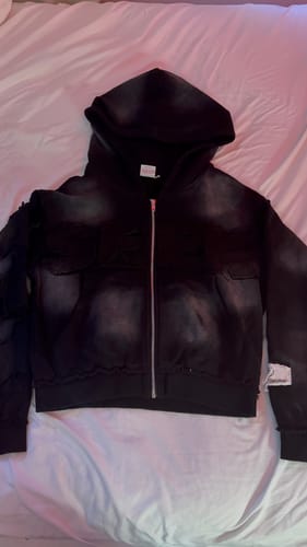 Customer's black acid-washed zip-up hoodie from the SEEK VISIONZ SET laid out flat.