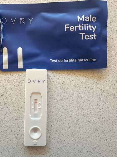 Customer's Male Fertility Test cassette showing a negative result, displayed next to its blue packaging.