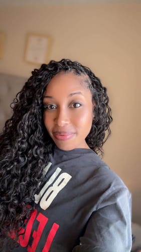 Reviewer smiling while wearing a full, wavy hairstyle using the Human Crochet Hair Water Wave.