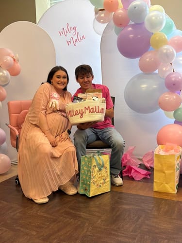 Customer holding their white personalized knitted basket with the name 'Miley Malia' at a baby shower.