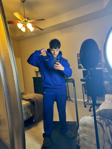 Reviewer taking a mirror selfie in a matching blue sweatsuit, showing the fit of the Haus Core Ultra-Soft Sweats.
