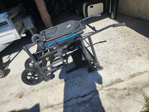 Klant toont de Preston Absolute 36 Feeder Chair Wheel Kit, gemonteerd op een stoel en klaar voor transport.