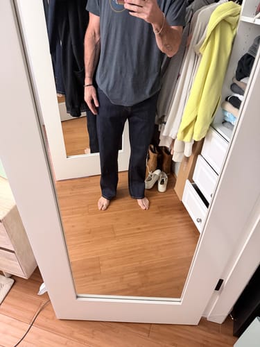 Reviewer's front-facing mirror view showing the fit of the black Straight-Fit Jeans.