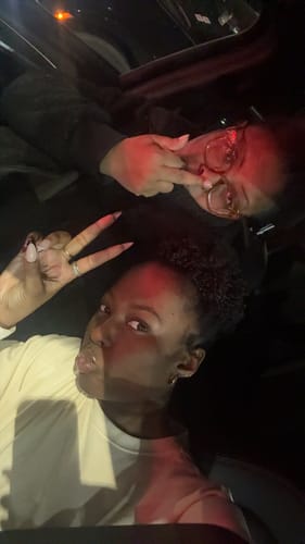 Reviewer and a friend posing for a selfie inside a car at night.