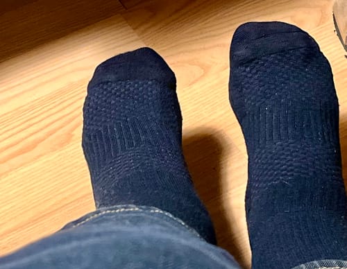 Anmelder der har de mørke, teksturerede støttestrømper på fødderne.