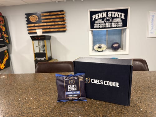 Customer's single Cael's Cookie package and black box displayed on a counter.