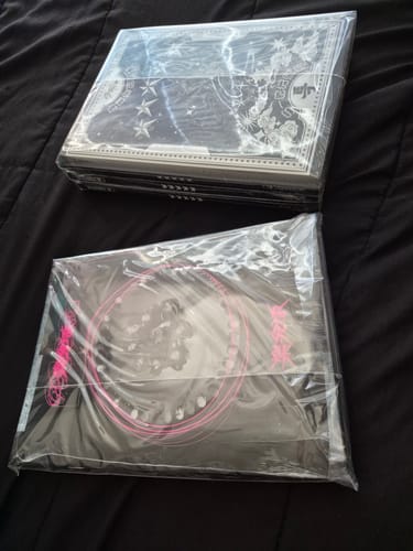 Customer's two sealed sets of STRAY KIDS albums, including ROCK-STAR, resting on a black surface.