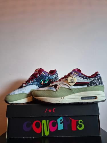 Recensent toont de opvallende Nike Air Max 1 SP Concepts 'Mellow' sneakers op de schoenendoos.
