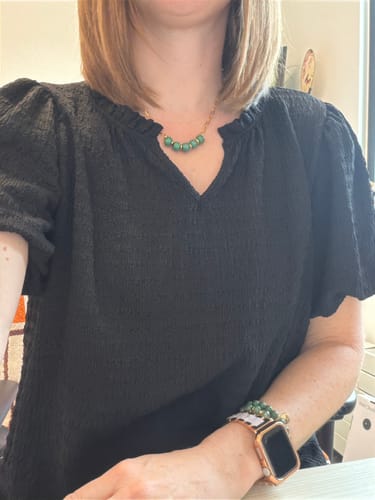 Reviewer wearing the black Textured Puff Sleeve V Blouse, showing the textured fabric and moderate puff sleeves.