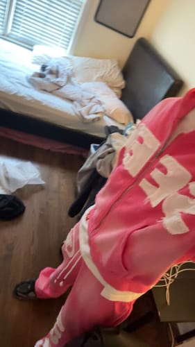Partial view: Reviewer wearing the pink SEEK VISIONZ SET, showing the zip-up hoodie and matching pants with white graphics.