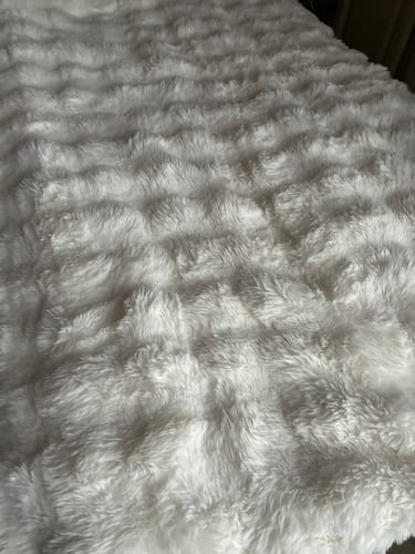 Close-up of the customer's fluffy white Nordic Cozy Blanket, showing its soft textured pattern.