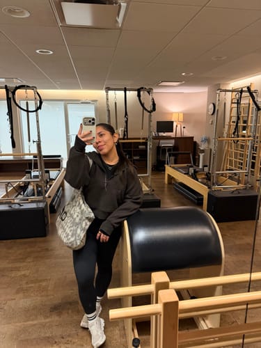Customer in a pilates studio wearing the striped Dual-Direction Grip Stripes in Coconut Cream.