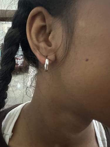 Customer wearing the small, shiny Silver Classic Hoop Earring in their ear.