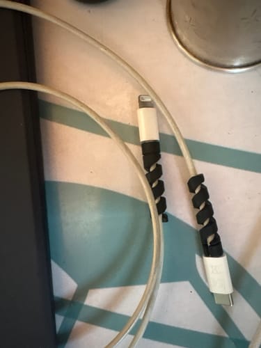 Customer's two black cable protectors wrapped around the ends of white Lightning and USB-C cables.