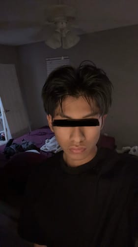 Reviewer in a bedroom showing their dark hair styled with volume using the Pomade.