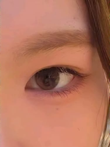 レビュアーの目のクローズアップ。Dewy Kristin Basic ブラウンを装着し、自然でうるおいのある瞳に見えます。