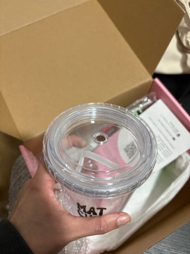 Primer plano del Vaso Oficial de Matchaflix de un cliente, mostrando la tapa transparente con un pequeño roto.