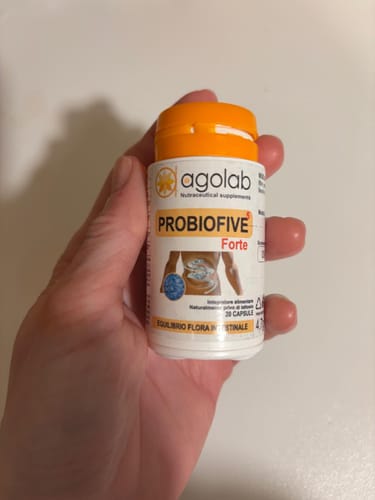 Un recensore tiene in mano il flacone di probiotici Probiofive Forte.