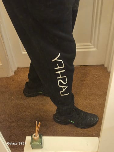 Close-up view of a reviewer wearing the black Fitted Sweatpants, showing the fit at the ankle.