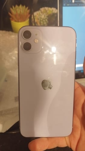 Reviewer holding the back of the purple refurbished iPhone 11, showing the dual cameras.