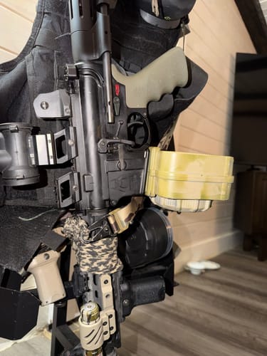 Customer's AR-15 rifle with the Partisan Forced-Reset Trigger installed, shown resting against a tactical vest.