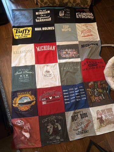 Customer's finished Project Repat T-Shirt Quilt, featuring a colorful grid of memory t-shirts laid out flat.