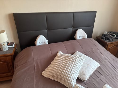 Photo d'un client montrant deux coussins orthopédiques Cellsius blancs posés sur un lit.