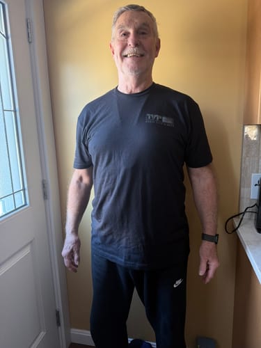 Customer wearing the black T.V.P. Elite Membership t-shirt, showing the small logo on the front.