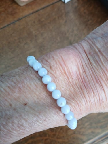 Un client porte le bracelet en calcédoine bleue au poignet.