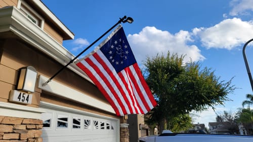 Reviewer's America 250™ flag mounted on a flagpole attached to the front of their house.