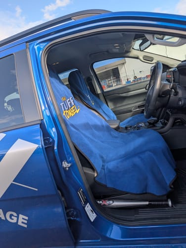 Customer's two blue Tuff Towel seat covers installed on the front seats of a branded work vehicle.