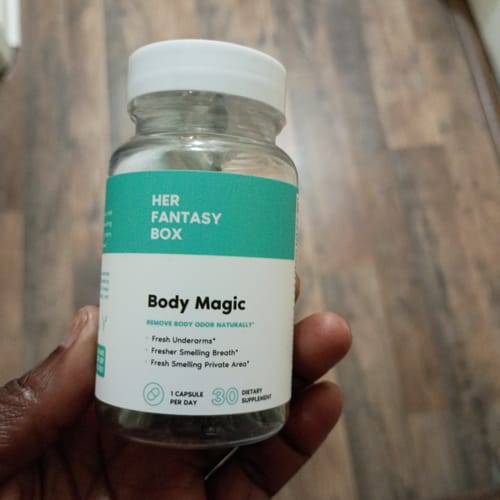 Customer holding the clear bottle of Her Fantasy Box Body Magic chlorophyll pills.