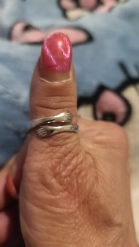 Close-up of a customer's thumb wearing the silver Hug From Heaven Ring.