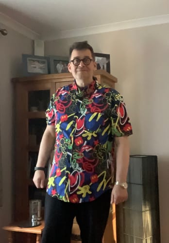 Reviewer wearing the colorful, graffiti-style Disney 'Outside the Lines' shirt indoors.