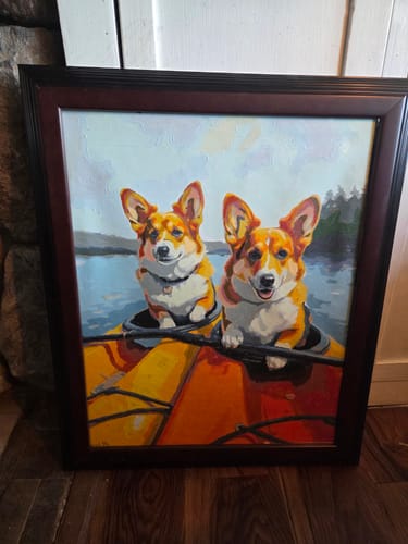 Customer's finished paint by numbers project showing a framed painting of two happy corgis in a kayak.